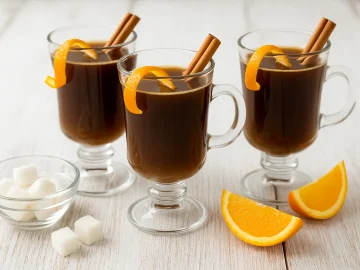 Café Martinique mit Rum, Orangenschale und Zimtstange im Glas serviert