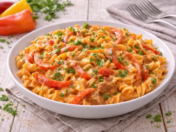 Paprikanudeln mit Paprikastreifen und cremiger Soße auf weißem Teller