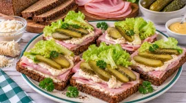Schwarzbrotschnitten mit Schinken, Meerrettich und Gewürzgurken.
