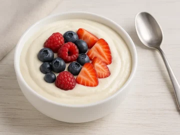 Quark-Vanille-Soße mit Quark, Vanille und Beeren in einer weißen Schale serviert