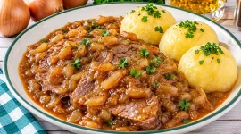 Geschmortes Zwiebelfleisch nach Sachsenart mit Rindfleisch, Zwiebelsauce und Kartoffelklößen.