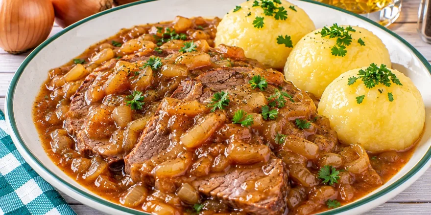 Geschmortes Zwiebelfleisch nach Sachsenart mit Rindfleisch, Zwiebelsauce und Kartoffelklößen.
