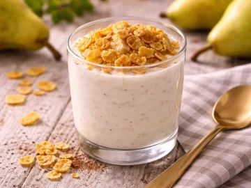 Cremiger Birnenjoghurt im Glas mit Knusperflocken und Zimt