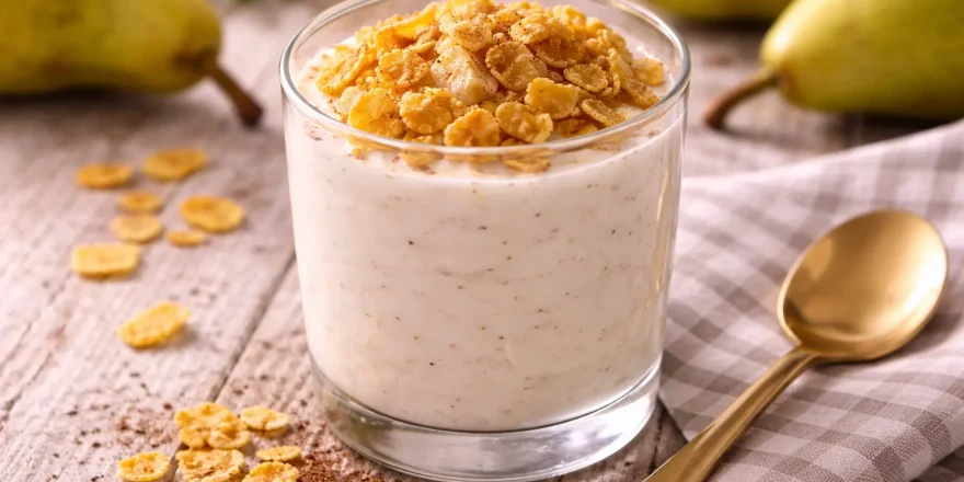 Cremiger Birnenjoghurt im Glas mit Knusperflocken und Zimt