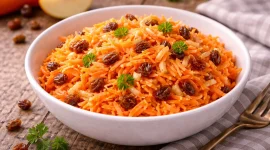 Geriebene Möhren und Äpfel mit Sultaninen in einer Schüssel