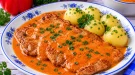 Gebratenes Schweineschnitzel mit cremiger roter Paprika-Sahne-Soße.