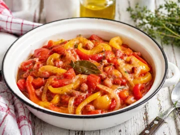 Tomaten-Paprika-Gemüse mit Speck in rustikaler Emaille-Schüssel angerichtet