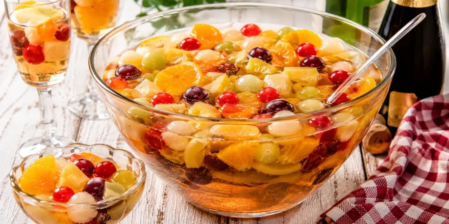 Rumfrüchtebowle mit Früchten, Weißwein und Sekt in Glasschüssel angerichtet
