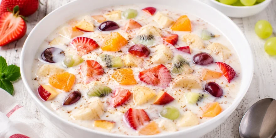 Buttermilch-Frucht-Kaltschale mit frischen Früchten in weißer Schüssel