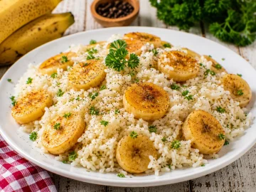 Bananenreis mit goldbraun gebratenen Bananenscheiben auf weißem Teller