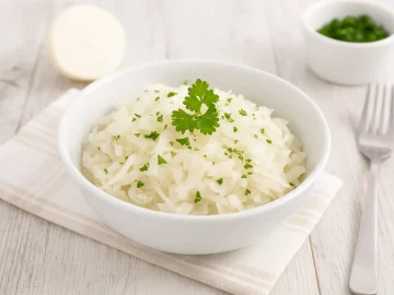 Rettichsalat mit Zwiebeln und frischer Petersilie in weißer Schüssel auf Holztisch