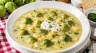 Cremige Rosenkohlsuppe mit Kartoffeln und saurer Sahne im weißen tiefen Teller