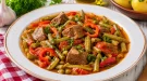 Ungarischer Bohnentopf mit Bohnen, Hammelfleisch und Paprika im weißen Teller