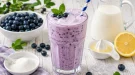 Cremiger Heidelbeer-Sahne-Drink mit frischen Heidelbeeren und Eiswürfeln in einem hohen Glas.