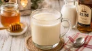 Heißer Honigpunsch aus Milch, Honig und Rum in einem Glasbecher.