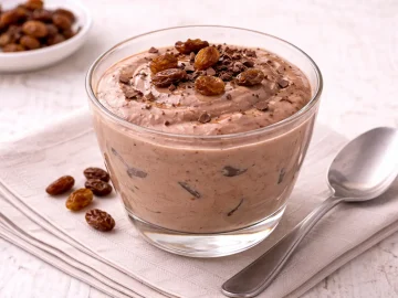 Cremiger Schokoladenjoghurt im Glas auf hellem Holztisch