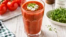 Herzhafter Vitamin-Drink aus Tomatensaft mit Kresse und einem Klecks saurer Sahne in einem hohen Glas.