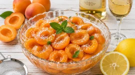 Frischer Aprikosensalat mit Zitronensaft und Dessertwein in einer Glasschüssel.