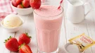 Cremiger Erdbeer-Milchshake mit Vanilleeis in einem hohen Glas.