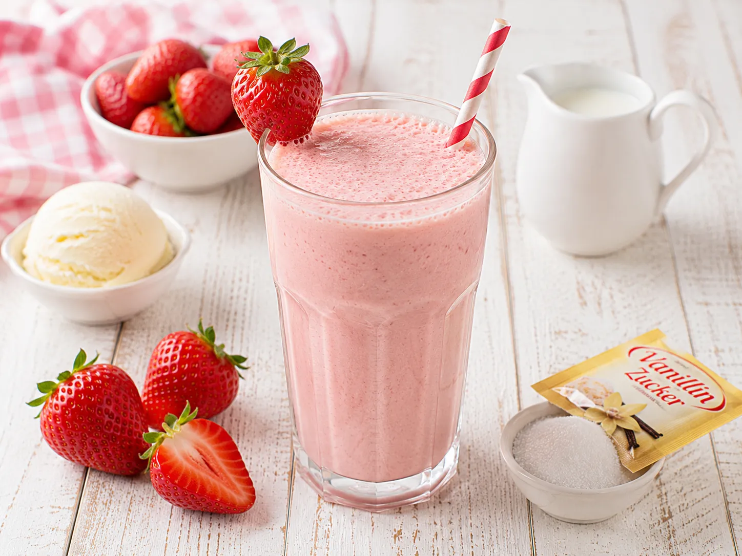 Cremiger Erdbeer-Milchshake mit Vanilleeis in einem hohen Glas.