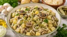 Kartoffelsalat mit Pilzen, Sauerkraut und Salzgurken in einer großen Schüssel.