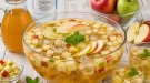 Große Glasschüssel mit Kinder-Apfelbowle und frischen Apfelstücken.