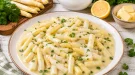 Brechspargel in cremiger heller Soße mit Petersilie auf einem Teller.
