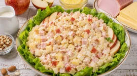 Fruchtiger Festtagssalat mit Äpfeln, Schinken, Käse und Ananas auf Kopfsalat.