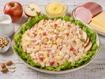 Fruchtiger Festtagssalat mit Äpfeln, Schinken, Käse und Ananas auf Kopfsalat.