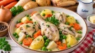 Gekochtes Hühnerfleisch mit Kartoffeln, Möhren und Erbsen in cremiger Brühe.