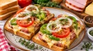Überbackener Toast mit Kasseler, Käse, Tomaten und Paprika.