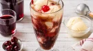 Hohes Glas Kirsch-Cola mit Vanilleeis und Maraschinokirsche.