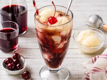 Hohes Glas Kirsch-Cola mit Vanilleeis und Maraschinokirsche.