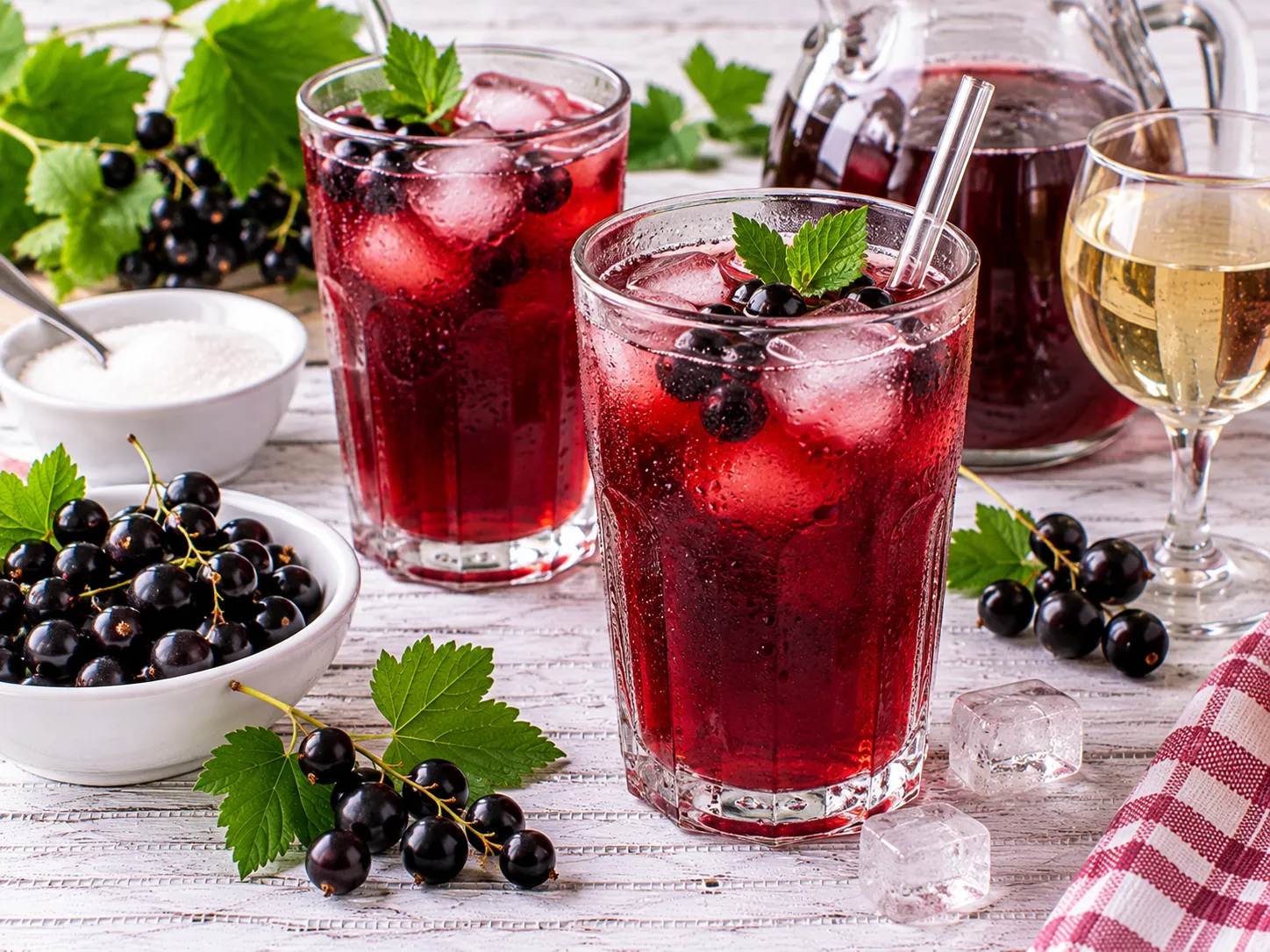 Erfrischendes Johannisbeergetränk mit schwarzen Johannisbeeren und Eiswürfeln.