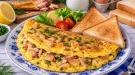 Locker gebratenes Omelett mit Räucherfisch und Toast.