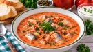 Cremige rote Fischsuppe mit Heringsstücken, Kapern und Petersilie.