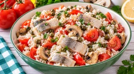 Herings-Reissalat mit Tomaten, Champignons, Kapern und lockerem Reis.