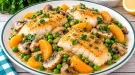 Gebratenes Kabeljaufilet mit Champignons, Erbsen und Aprikosenspalten.