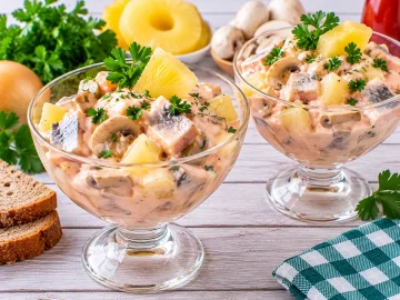 Matjescocktail im Glas mit Ananas, Champignons und cremiger Soße.