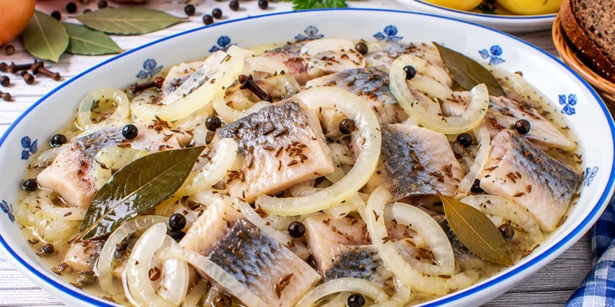 Dänische Kümmelheringe in süß-saurer Marinade mit Zwiebeln, Lorbeer, Pfeffer und Kümmel.