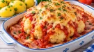 Ganzer Blumenkohl mit Tomatentunke, Schinken und geschmolzenem Käse überbacken.