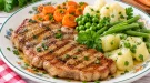 Gegrilltes Kalbssteak mit buntem Gemüse und frischen Kräutern.