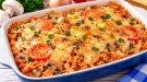 Italienischer Reistopf mit Champignons, Tomaten und geschmolzenem Käse.