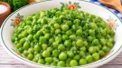 Junge grüne Erbsen mit Margarine und frisch gehackter Petersilie.