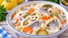 Marinierte Heringe mit Zwiebeln, Gurken, Möhren, Apfel und cremiger Soße.