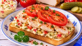 Budapester Hühnersandwich mit Hühnerbrust, Paprika, Gewürzgurke und Tomate.