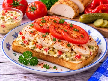 Budapester Hühnersandwich mit Hühnerbrust, Paprika, Gewürzgurke und Tomate.