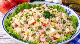 Bunter Reissalat mit Äpfeln, Schinken, Gewürzgurken, Ei und Petersilie.