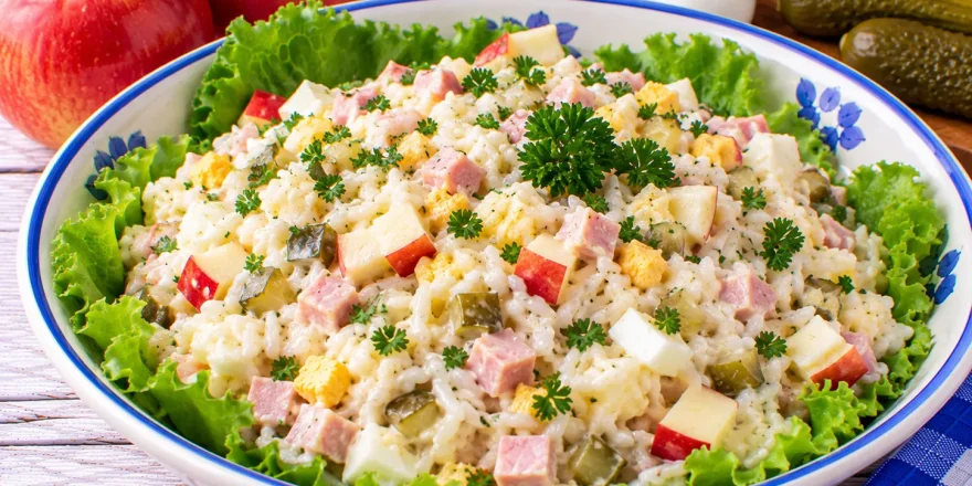Bunter Reissalat mit Äpfeln, Schinken, Gewürzgurken, Ei und Petersilie.