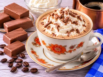 Heißer Nougatkaffee mit Milch und einer Haube aus geschlagener Sahne.